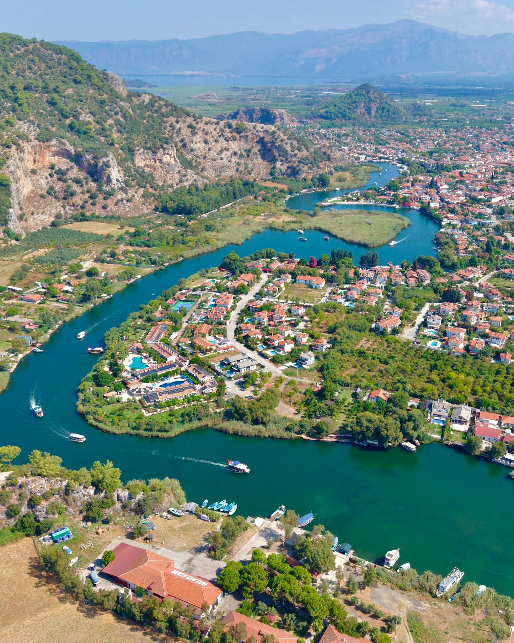 Aerial view of the Dalyan river winding through town with rock tombs visible on the far cliff